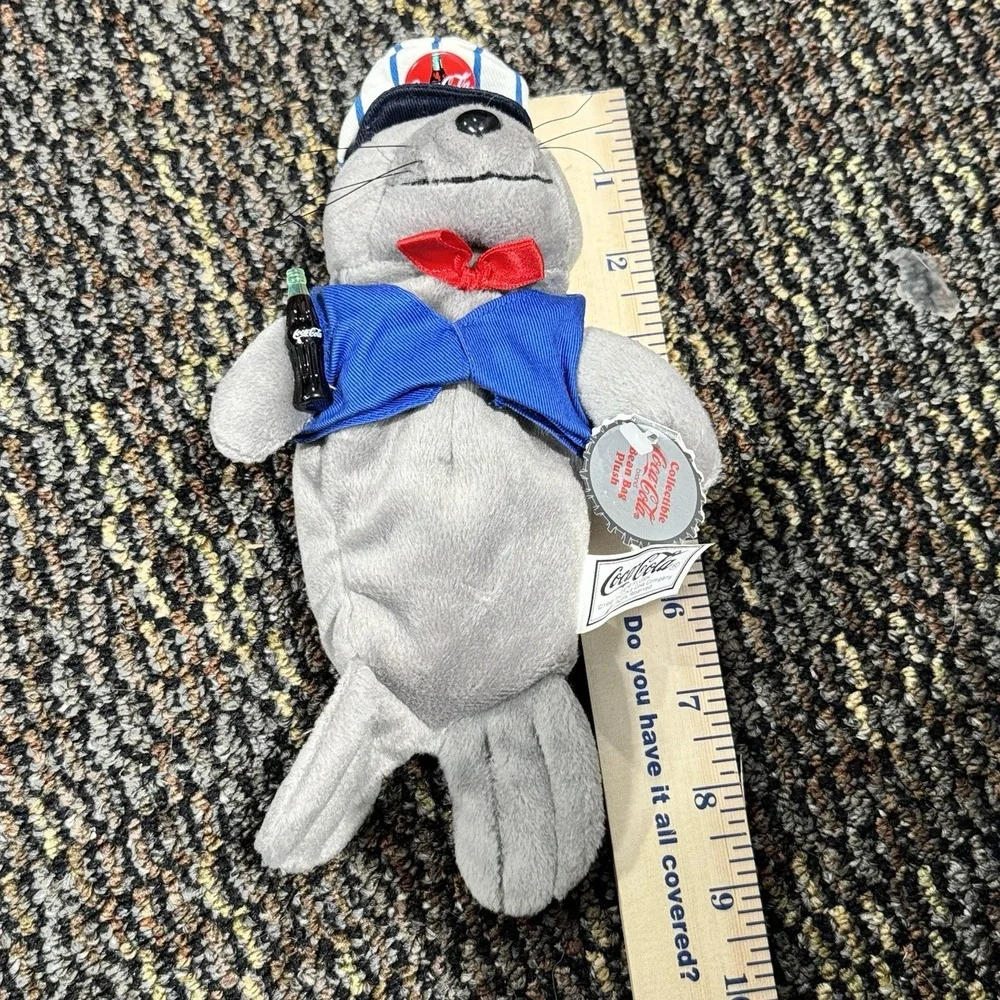 Coca-Cola collectible bean‎ bag plush seal from 1998, wearing a delivery outfit